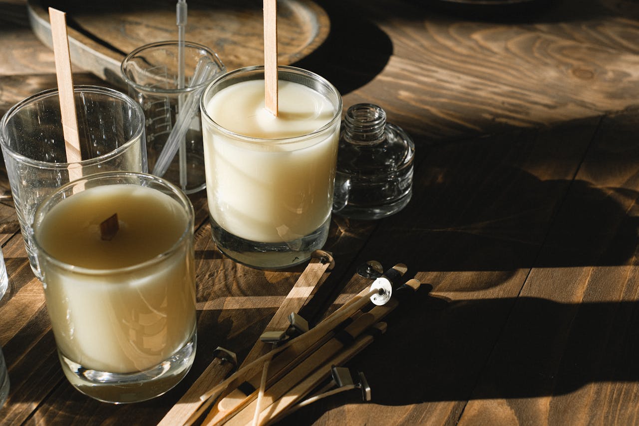 Handmade candles in an artisan workshop with natural light and wooden tools.